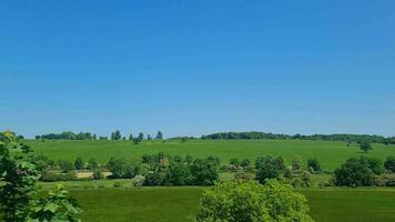 Outside View from Window Seat of Train Moving Fast to Approach Next Station After Hitchen. The Train is Traveling from Central Hitchen to London City of England of UK. Captured on June 4th, 2023 video