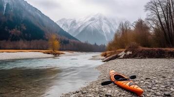Active rest, tourism. Kayak near river bank, mountain background. . photo