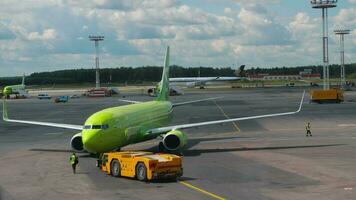 MOSCOW, RUSSIAN FEDERATION JULY 24, 2021 - Towing a Boeing S7 Airlines plane to the runway at Domodedovo airport, Moscow DME video