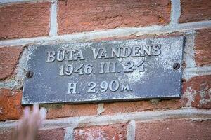 Kaunas, Lithuania - October 20 2022 Wall plate on red brick wall about water level during flood in 1946 photo