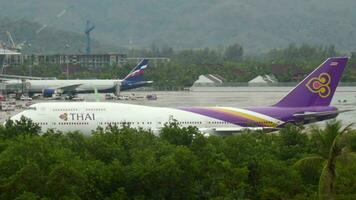 PHUKET, THAILAND DECEMBER 02, 2016 - Passenger huge liner Thai Airways accelerates to take off at Phuket airport, side view. Jumbo jet departure. Airfield, palm trees video