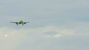 Jet vlak met groen kleurstelling in de lucht. vliegtuig naderen voor landen, voorkant visie. langzaam beweging, passagiersvliegtuig is vliegend video