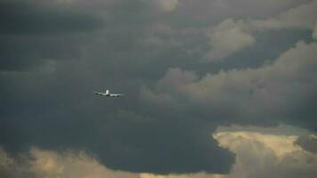 Jet airplane take off, climb in the dark stormy sky. Departing plane, rear view video