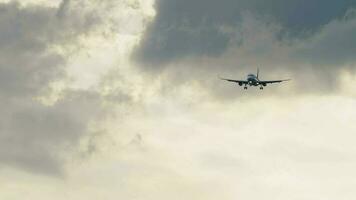 civil jet flygplan närmar sig landning, lång skott. trafikflygplan silhuett i mörk molnig himmel på skymning video