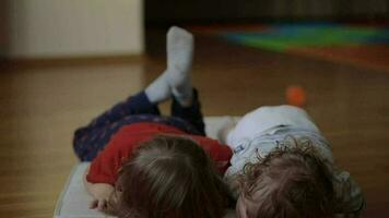 Brother and sister are playing together on the floor. Closeup video