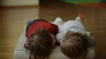 Brother and sister are playing together on the floor. Closeup video