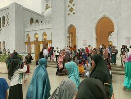 Solo - 2 June,2023 - a group of visitors taking selfies in front of the white mosque photo