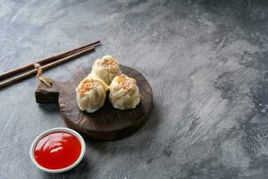 Chinese steamed dumplings or  Dim Sum in bamboo steamer on dark abstract background photo