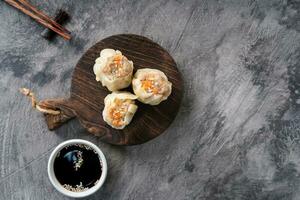Chinese steamed dumplings or  Dim Sum in bamboo steamer on dark abstract background photo