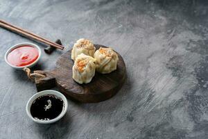 Chinese steamed dumplings or  Dim Sum in bamboo steamer on dark abstract background photo