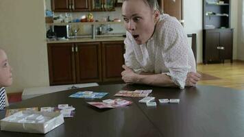 Young mother invites her daughter to play table game at the table video