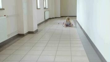 Girl of four years is crawling in the long corridor.Wide angle shot video