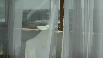 Diary with a pen at marble sill of an open window. Blowing grey transparent curtains video