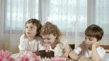 frère et le sœur sont lécher anniversaire gâteau. aîné frère est observer le processus. video