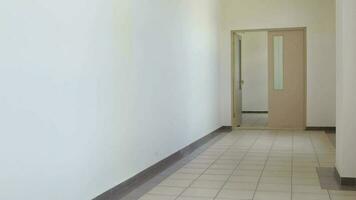 Medical sister in professional uniform with two funny children in the corridor of hospital. video