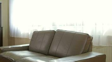 Empty leather sofa in the living room. White transparent voile in the background video