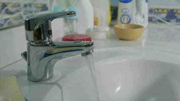 Flowing water from the tap in the bathroom. Closeup video