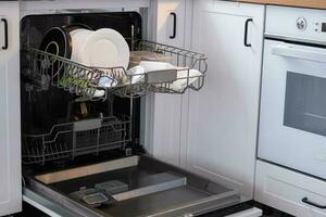 A lot of dirty dishes in the dishwasher. Helping the hostess, economy and ecology. Cleaning in the kitchen photo