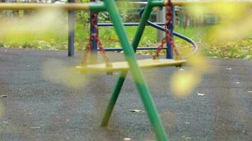 Empty playground, swing chair rocking alone in autumn playground video