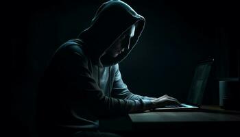 Hooded burglar typing crime on dark laptop generated by AI photo