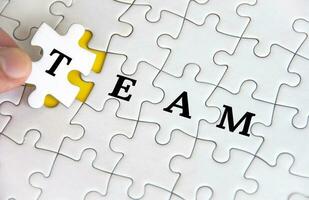 Team text on white jigsaw puzzle. Business and teamwork concept photo