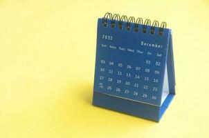 December 2023 blue desk calendar on yellow cover background with customizable space for text. Copy space and calendar concept photo