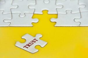 Trust text on missing jigsaw puzzle on yellow background photo