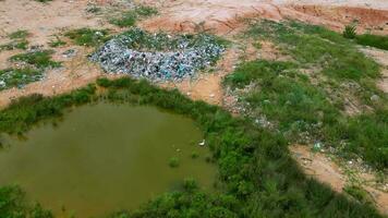 Aerial view rubbish landfill site near pond in Malaysia video