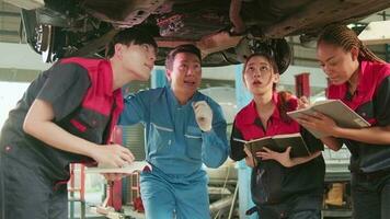Specialist lecture, male supervisor engineer describe gasoline automotive fixing with mechanic worker staff teams for repair work at car service garage and maintenance jobs in automobile industry. video