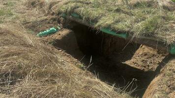 Close up ready trenches with hay stacks and grass camouflage in forest outdoors in military zone video