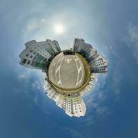 tiny planet in blue sky with clouds in city center near modern skyscrapers in residential complex. Transformation of spherical 360 panorama in abstract aerial view. photo