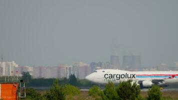 NOVOSIBIRSK, RUSSIAN FEDERATION JUNE 17, 2020 - Huge cargo airplane Boeing 747 Cargolux taxiing at Tolmachevo airport, side view. Freight transport carrier. Haze on airfield video