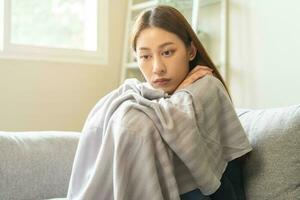 Sad, unhappy. Alone asian young woman, girl expression face thinking about problem, difficulty, feeling failure and exhausted, suffering sitting on sofa, grief sorrow and bad relationship or break up. photo