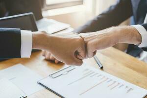 Congrats, business partnership people, two asian and caucasian young man fist bumping, shaking hands together with partnership, customer or colleague after work is done, successful. Worker meeting. photo