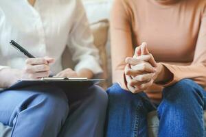 Psychology, depression. Sad, suffering asian young woman, consulting with psychologist, psychiatrist while patient counseling mental problem with doctor at clinic. Encouraging, therapy, health care. photo