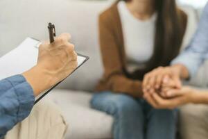 psicología, depresión asiático joven pareja, paciente consultante problema mental salud con psicólogo, psiquiatra a clínica juntos, marido alentador por participación mano de esposa, terapia salud cuidado foto