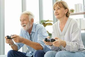 Happy senior couple, elderly family, Hand of caucasians mature, adult lover and retired husband, wife having fun, playing video game together, sitting cozy on sofa in living room at home, technology. photo