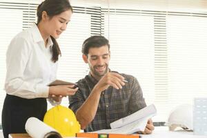 Construction of Engineer, architect businessman, woman making on blueprint of house building in office together, meeting plan working with partner team colleagues on blueprint, discussing design. photo