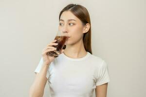 Thirsty, attractive asian young woman, girl drink or sip, holding a glass of cold sparkling water with ice in hand, refreshness people, isolated on white background. Temptation of food, health care. photo