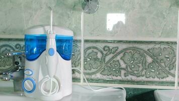 Home dental care device - water flosser in the bathroom. Closeup video