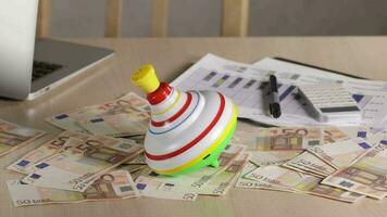 Colorful spinning top on a office table. Closeup video