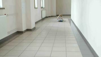 menina do quatro anos é rastejando dentro a grandes corredor.largo ângulo tiro video