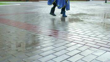 Two children - brother and sister are jumping in the puddle after rain. video