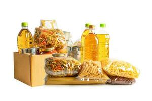 Foodstuff for donation isolated on white background, storage and delivery. Various food, pasta, cooking oil and canned food in cardboard box. photo