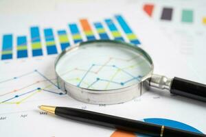 Magnifying glass on graph paper. Financial development, Banking Account, Statistics, Investment Analytic research data economy, Business concept. photo