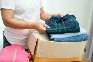 Donation box with used clothes at home to support help for poor people in the world. photo