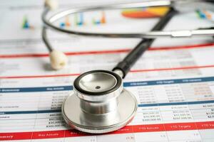 Stethoscope on spreadsheet and graph paper, Finance, Account, Statistics, Investment, Analytic research data economy and Business company concept. photo