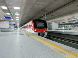 The modern commuter train of the urban public transport system is parked on the platform. photo