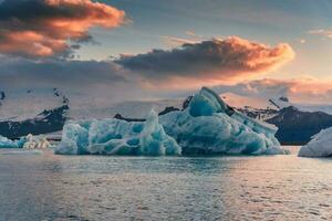 Scenery of Jokulsarlon glacier lagoon with blue iceberg melting and sunset sky on summer photo