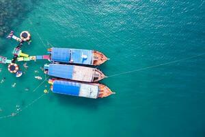 Traditional ferry anchored and tourist snorkeling and enjoying with coral reef in tropical sea photo